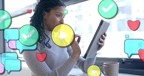 Woman at window tapping tablet, bringing chats, checks, play icon around her Stock Footage 331024828