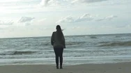 Woman With Windswept Hair Standing Near The Sea Coast Stock Footage