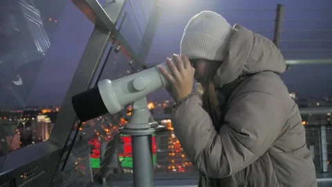 Woman in winter clothes using a coin-operated telescope on an observation deck 스톡 동영상 295530068