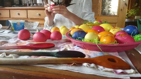 Woman wipes painted easter eggs, decorated bowl with colorful eggs on table Vídeos de archivo 76282511