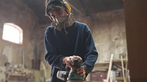 Woman work at carpentry workshop. Carpenter grinding wood. Joiner use sander. 動画素材 271221960