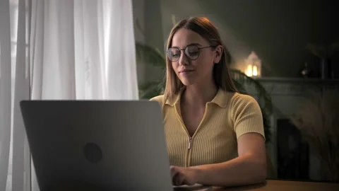 Woman work remotely using laptop sitting at table in home interior.Young blonde Stock Footage 209827827
