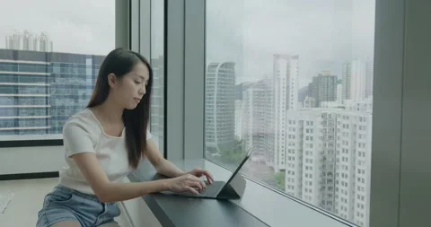 Woman work on tablet computer beside window Stock Footage 161444264