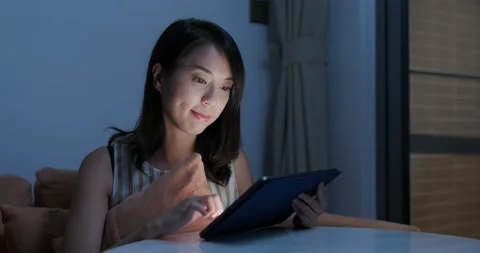 Woman work on tablet computer at night inside home Stock Footage 131781455