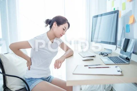 Woman worker back pain in office Stock Photos