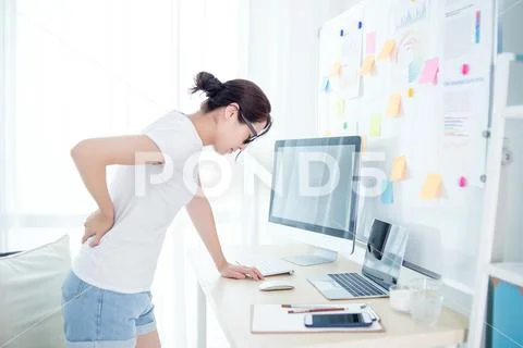 Woman worker back pain in office Stock Photos