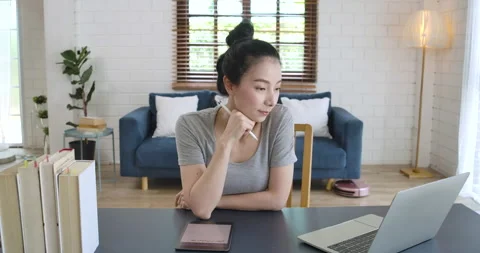 Woman working and taking notes while looking at laptop screen. Video stock 132834727