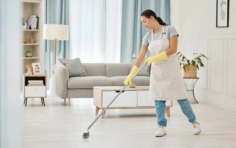 Woman working in a cleaning service mopping the living room floor of a modern Stock Photos