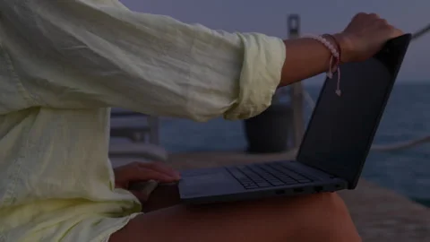 A woman is working on a computer at the beach. Stock Footage 282237347