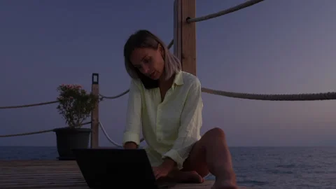A woman is working on a computer at the beach. Stock Footage 282237384