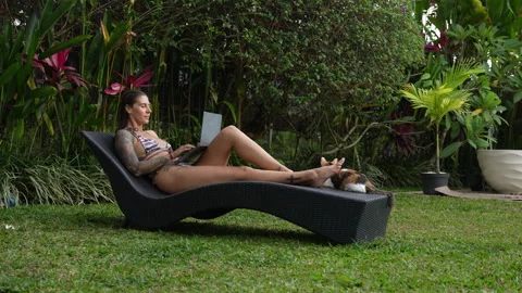 The woman is working on computer in beautiful backyard her Bali house Stock Footage 288831409