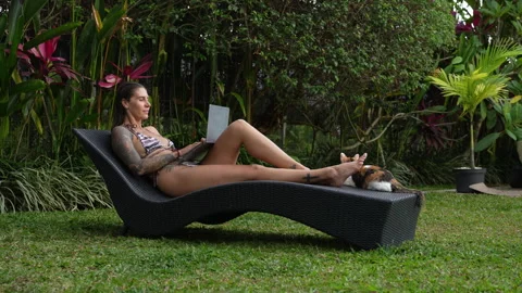 The woman is working on computer in beautiful backyard her Bali house Stock Footage 288981145