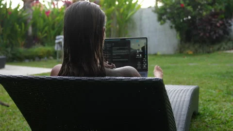 The woman is working on computer in beautiful backyard her Bali house Stock Footage 288987454