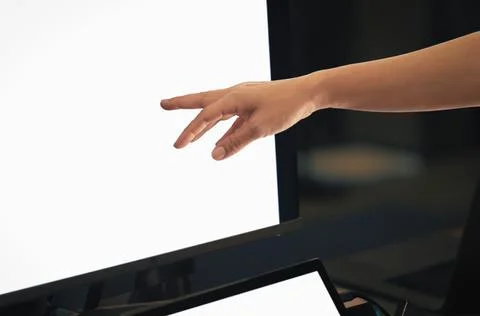 Woman working on computer with hand pointing at desktop screen. 스톡 사진