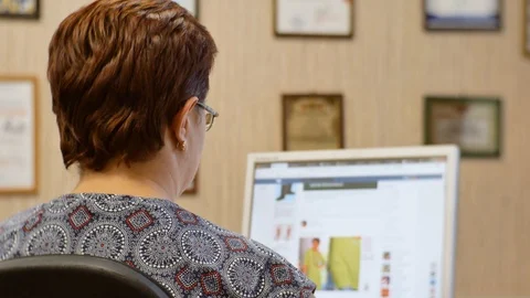 A woman working at a computer in the office. Stock Footage 116483981