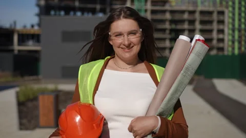 Woman Working on a Construction Site While Holding Blueprints in Hand Stock Footage 311857348