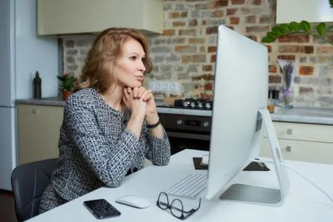 A woman working on a desktop computer with her employees at a video conferenc Stock Photos