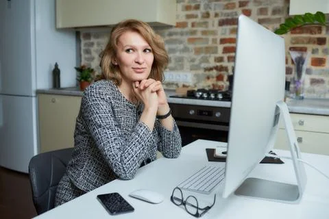 A woman working on a desktop computer with her employees at a video conferenc Stock Photos