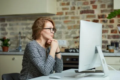 A woman working on a desktop computer with her employees at a video conferenc Stock Photos