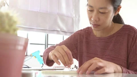 A woman is working on a device with a multimeter Video stock 318914313
