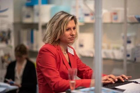 Woman working with her computer while attending an event at the convention tr Stock Photos