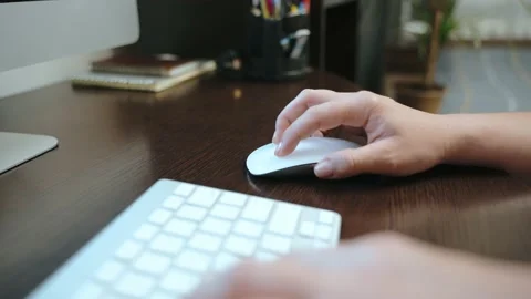 A woman working from home controls a computer with a wireless mouse. Stock Footage 213727353
