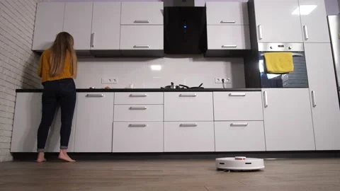 Woman working in home kitchen while robot cleaning Stock-Footage 145018007