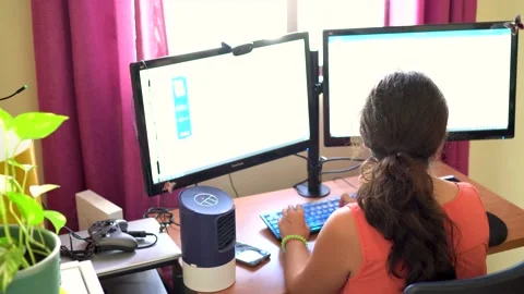 Woman working from home using a computer with two monitors in a bright workpl Stock Footage 163217282
