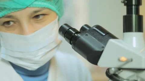 Woman working in a laboratory at the microscope close up Stock Footage 129111384