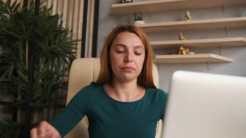 Woman working on laptop computer looking away thinking solving problem at home  Video stock 136722809