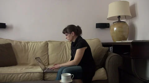 Woman working on laptop, computer, typing, job, home, couch Vídeos de archivo 35326401