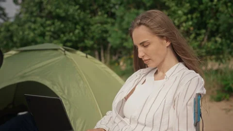 Woman Working on Laptop While Sitting in Camping Chair near Tent Stock Footage 343239466
