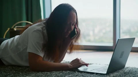 Woman Working on Laptop while Talking on Phone Video stock 332322275