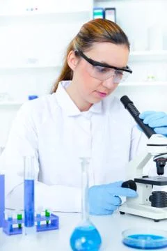 Woman working with a microscope in a lab Stock Photos