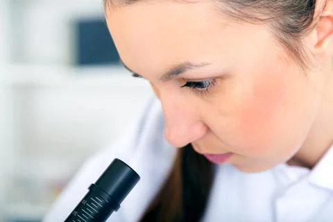 Woman working with a microscope in a lab Stock Photos