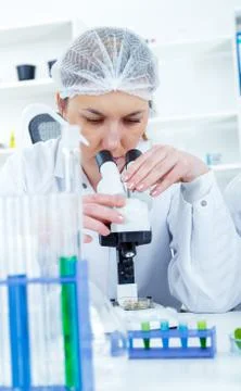 Woman working with a microscope in a lab Stock Photos