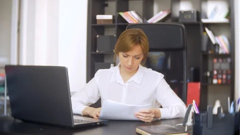 Woman working in office with documents and laptop. Stock Footage 88195079
