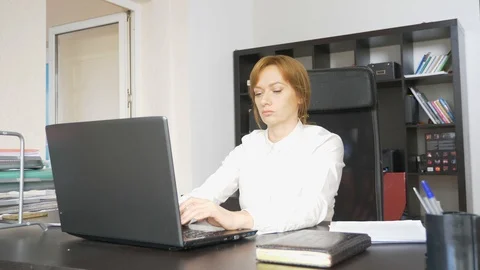 Woman working in office with documents and laptop. 4k. Stock Footage 88634991