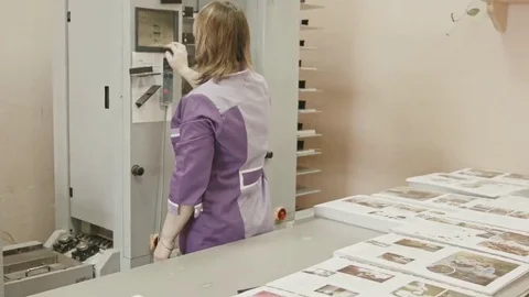Woman working on polygraph folder machine in printing house Stock Footage 69126422