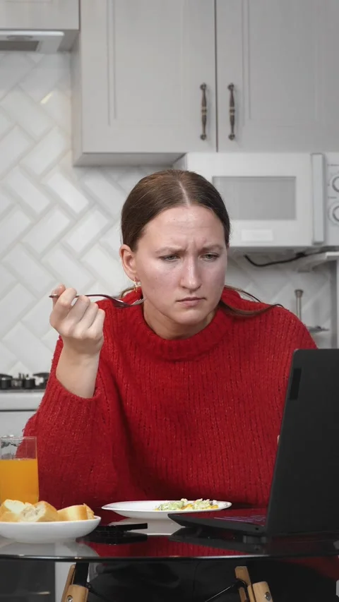 Woman working remotely and having breakfast in kitchen Stock Footage 308232953
