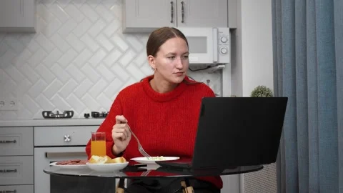 Woman working remotely and having breakfast in kitchen 스톡 동영상 308259608