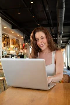 Woman working remotely at cafe using laptop computer Stock Photos