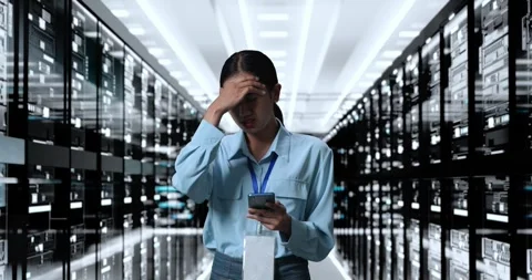 Woman Working In Server Room Database. Working On Smartphone, Having Problem Stock Footage 248005108