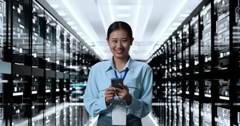 Woman Working In Server Room Database. Smiling To Camera While Using Stock Footage 248005278