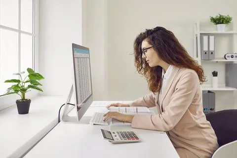 Woman working with spreadsheets on desktop computer in office Stock Photos
