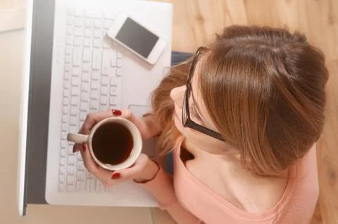 A woman is working by using a laptop computer on table at home Stock Photos
