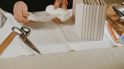 A woman working in the workshop, cuts the textile insert with scissors Stock Footage 110830207