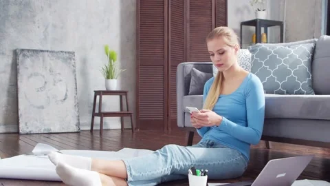 Woman works with documents using smartphone and laptop while sitting on the Stock Footage 169654115