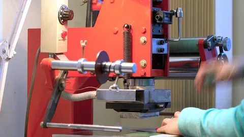 The woman in the workshop use press machine to get the embossed details Stock Footage 120898943
