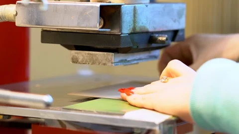 The woman in the workshop use press machine to get the embossed details Stock Footage 120899009